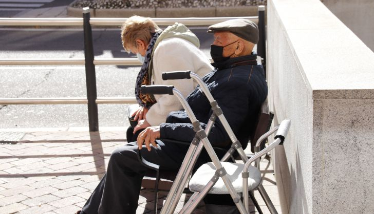 Personas mayores sentados en un banco de la calle 