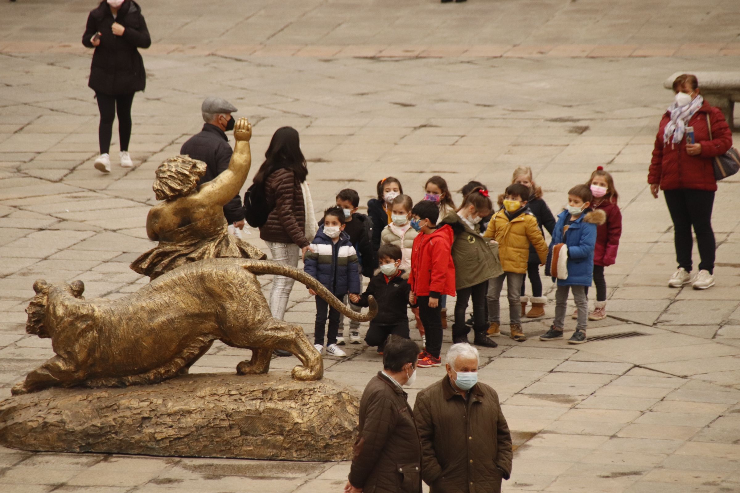 Grupo de niños mirando la estatua de la plaza mayor sin abanico otra