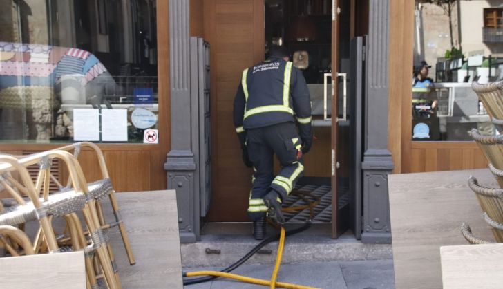 Momento en el que los bomberos sofocan un incendio declarado en un restaurante de la calle Sánchez Barbero durante la mañana de este domingo | Salamanca 24 Horas